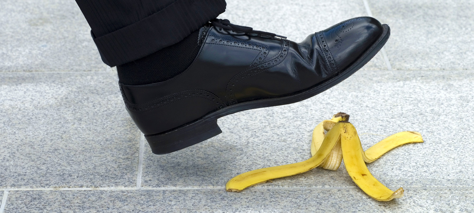 Man with dress shoe about to step on banana peel